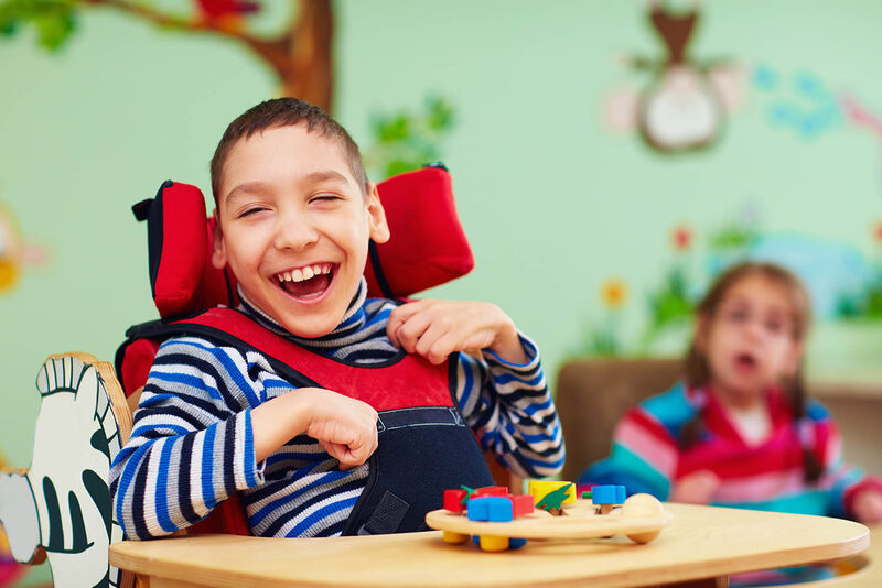 Child with developmental disabilities smiling in a care setting